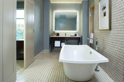 a bathroom with a white tub and a sink at Hyatt Regency Atlanta Perimeter at Villa Christina in Atlanta