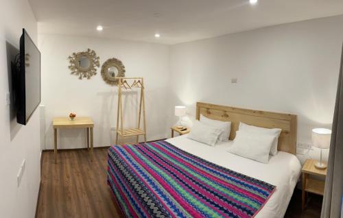 a bedroom with a bed with a colorful blanket at CASA CRISTOBAL Siete Cuartones in Cusco