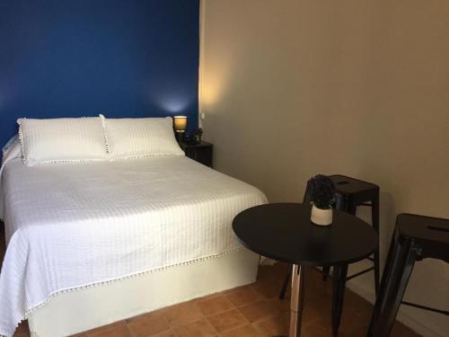 um quarto com uma cama branca e uma mesa em HOTEL COMERCIO PLAYA em Montevidéu