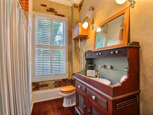 bagno con lavandino in legno e servizi igienici. di Washington Square Manor a Savannah