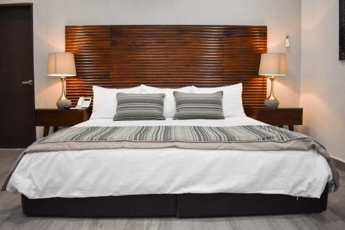 a bedroom with a large white bed with two lamps at Hotel Plaza Cuatro Ciénegas in Cuatrociénegas de Carranza