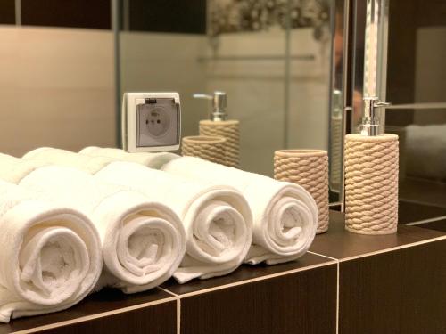 a pile of towels on a counter in a bathroom at BALTICUS uroczy apartament w Świnoujściu in Świnoujście