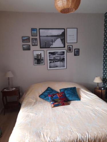 um quarto com uma cama com fotografias na parede em Aux Glycines em Marcilly-Ogny