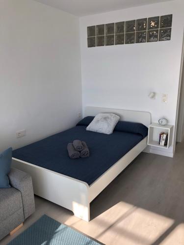 een bed in een witte kamer met een blauw matras bij Studio Infinity Sea in Aguadulce