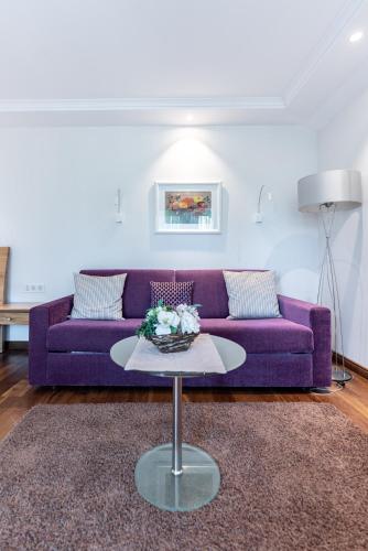 a purple couch in a living room with a table at Hotel Zum Ochsen in Schonwald im Schwarzwald