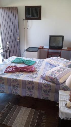a bedroom with a bed with a table and a tv at Espaço Trilegal in Porto Alegre