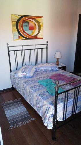 a bedroom with a bed and a painting on the wall at Espaço Trilegal in Porto Alegre