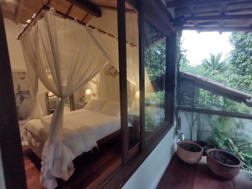 a bedroom with a bed and a window at Monkey Casa Hotel in Trancoso