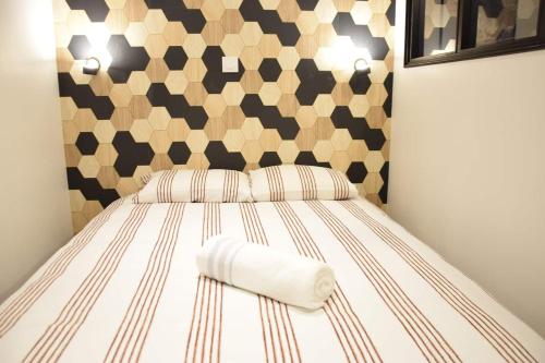 um quarto com uma cama com uma cabeceira geométrica em DESIGN APPART - HYPER CENTRE - TRAM - FREE WIFI - leRelaisdOdile21 em Valenciennes