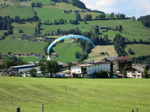 a blue parachute is flying over a green field at Ferienwohnungen Marchanger in Niederau