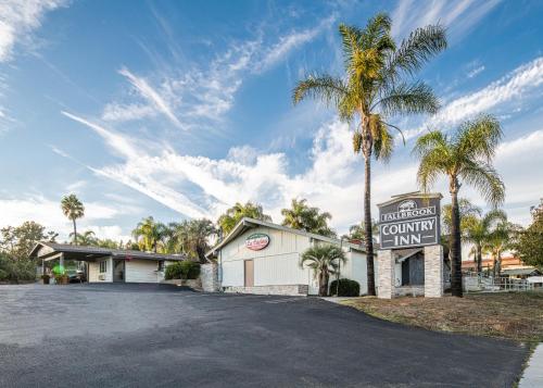 a sign for a community inn with a palm tree at Fallbrook Country Inn in Fallbrook