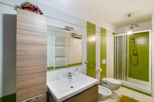 a bathroom with a sink and a toilet at Appartamento IL NIDO tra verde e natura in Berbenno di Valtellina