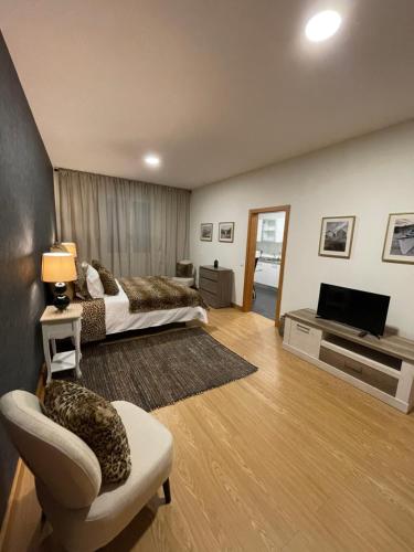 a room with two beds and a television and a couch at Queimada Houses in Funchal