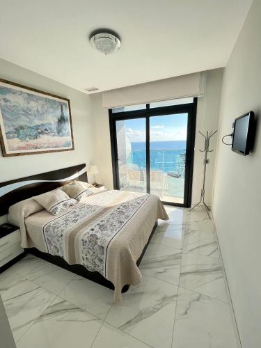 a bedroom with a bed and a view of the ocean at Sunset Drive Resort & Spa in Benidorm