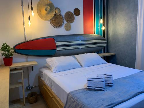 a bedroom with a bed with a surfboard on the wall at Casa Sete Mares in Guarujá