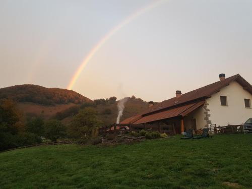 a rainbow over a house with a house at Hostal Rural Iratiko Urkixokoa in Orbaiceta