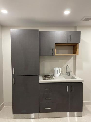 a kitchen with a refrigerator and a sink at روشن الماسي للشقق المخدومة in Yanbu
