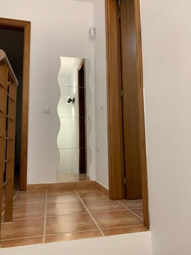 un pasillo con una puerta de cristal que conduce a un armario en Casa Los Majos, en Corralejo