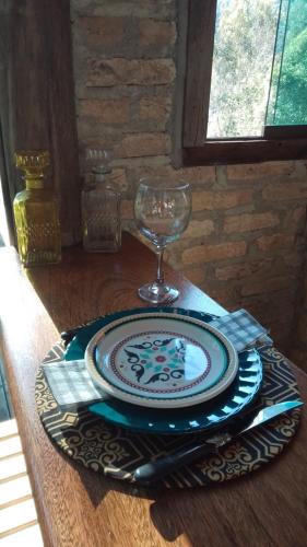 a plate and a wine glass on a table at chale opucv in Gonçalves