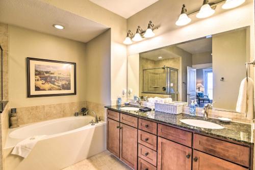 a bathroom with a tub and a sink and a tub and a large mirror at Driftwood Galveston Resort Escape with Deck and View in Galveston