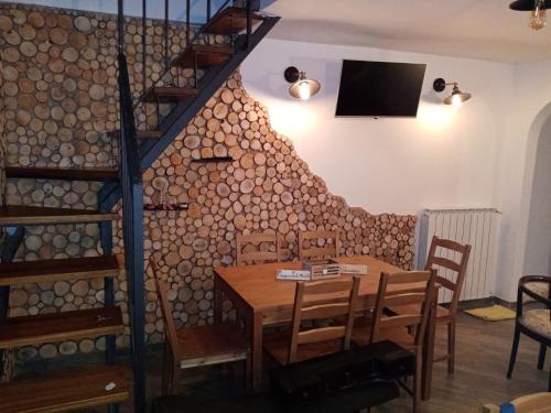 a dining room with a wooden table and a staircase at B&B IL VECCHIO LUPO in Campo di Giove