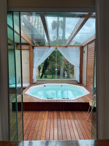 a jacuzzi tub in a patio with a window at Chalé do Tabuleiro in Aguas Mornas