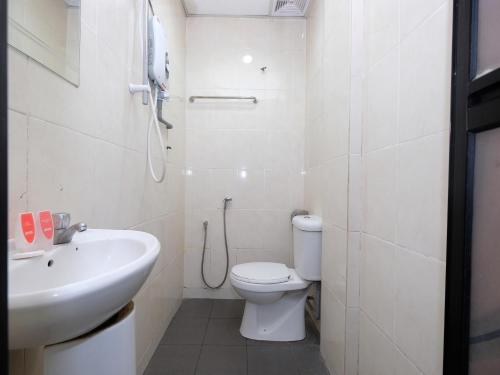 a white bathroom with a toilet and a sink at Marjan Hotel Sdn Bhd in Cukai