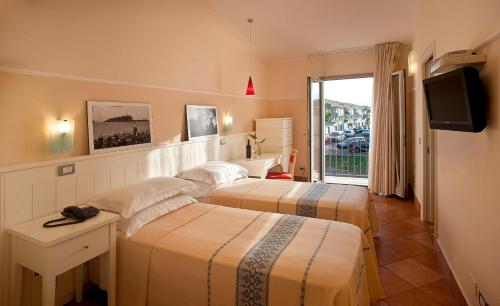 a hotel room with two beds and a television at Marin Hotel in Pula