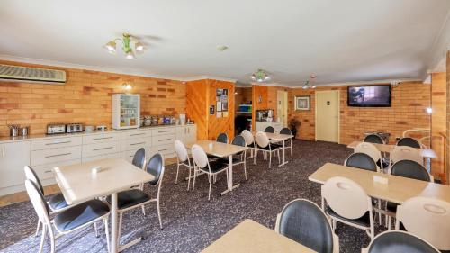 a classroom with tables and chairs and a kitchen at North Parkes Motel in Parkes