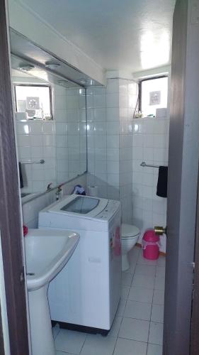 a white bathroom with a sink and a toilet at Canto del agua in La Serena