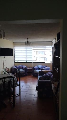 a living room with couches and a table and a window at Canto del agua in La Serena
