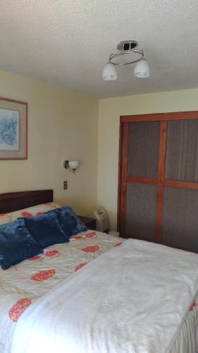 a bedroom with a bed with blue pillows on it at Canto del agua in La Serena