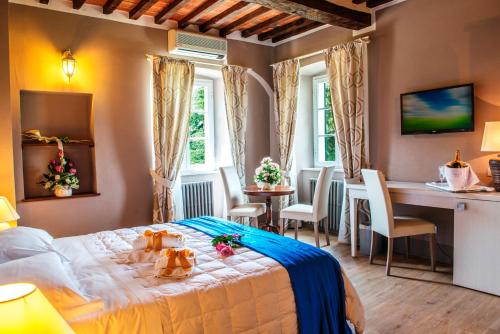 a bedroom with a bed and a table and chairs at Cortona Resort & Spa - Villa Aurea in Cortona