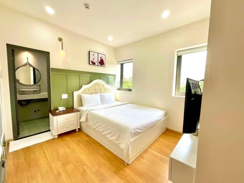 a bedroom with a white bed and a mirror at Khải Hoàn Hotel 2 in Bến Cát