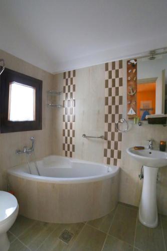 a bathroom with a large tub and a sink at Ικαριων Γη in Manganítis