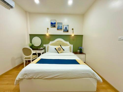 a bedroom with a large bed and a desk at Khải Hoàn Hotel 2 in Bến Cát