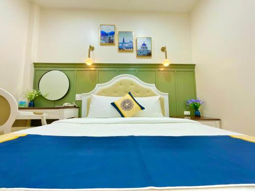 a bedroom with a large bed with a green headboard at Khải Hoàn Hotel 2 in Bến Cát
