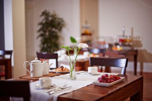 a table with a plate of fruit and flowers on it at Marin Hotel in Pula