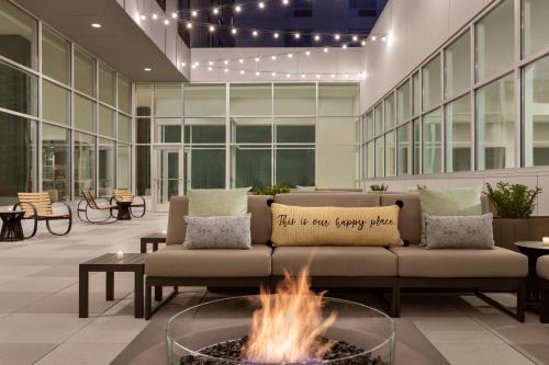 a living room with a couch and a fire pit at EVEN Hotels Rochester - Mayo Clinic Area by IHG in Rochester