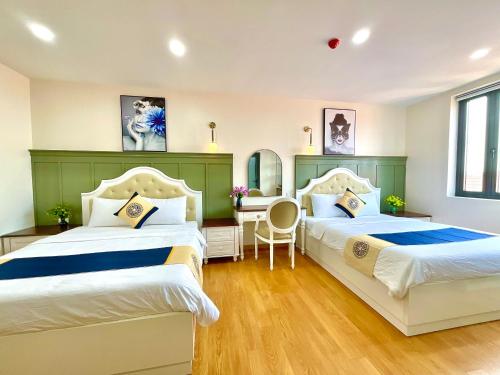 a bedroom with two beds and a desk in it at Khải Hoàn Hotel 2 in Bến Cát