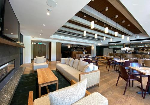 a restaurant with a couch and tables and a fireplace at Sudima Queenstown Five Mile in Queenstown