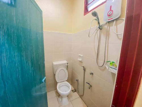 a bathroom with a toilet and a shower at Lagenda Resthouse Langkawi in Pantai Cenang