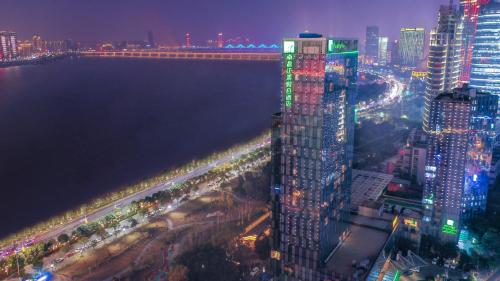 a city skyline at night with a tall building at Holiday Inn Nanchang Riverside by IHG in Nanchang