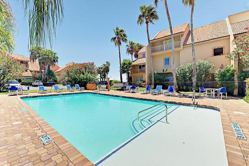a large swimming pool with chairs and palm trees at La Solana Condominiums #111 in South Padre Island