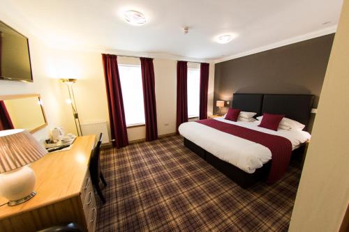 a hotel room with two beds and windows at Somerton House Hotel in Lockerbie