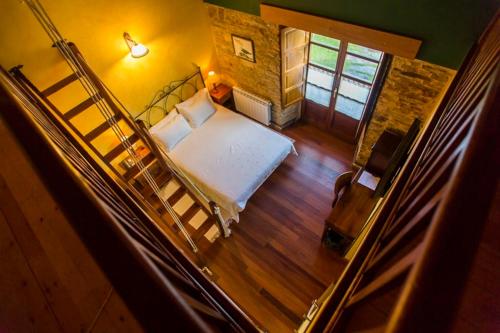 a small bedroom with a bed and a staircase at Casa do Merlo in Barreiros