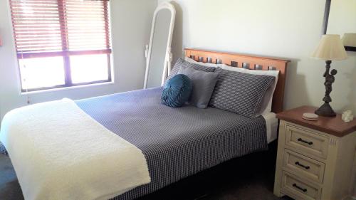 um quarto com uma cama com uma almofada azul em Quiet location ,central to city em Hamilton