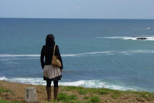 a woman standing on a hill looking at the ocean at Casa do Merlo in Barreiros