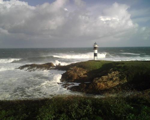 a lighthouse on the edge of the ocean at Casa do Merlo in Barreiros
