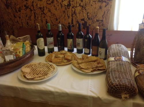 a table with bottles of wine and plates of food at Le Copertelle Bed & Breakfast in Serra San Quirico